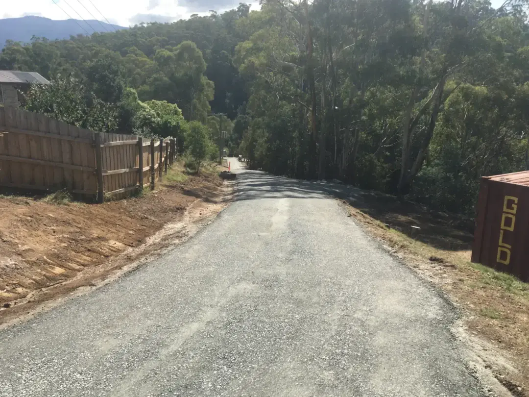 Completed gravel driveway winding through bushland to the house