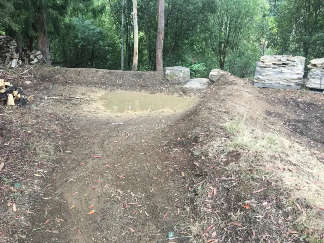 Cleared and graded section of the block with sandstone flagstone pallets ready for use