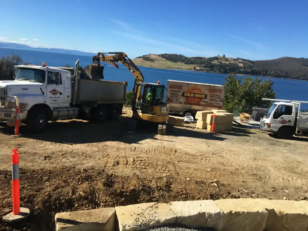 Solid Rock Tasmania crew and machinery on a Tinderbox site overlooking the Derwent, sandstone blocks stacked ready for use